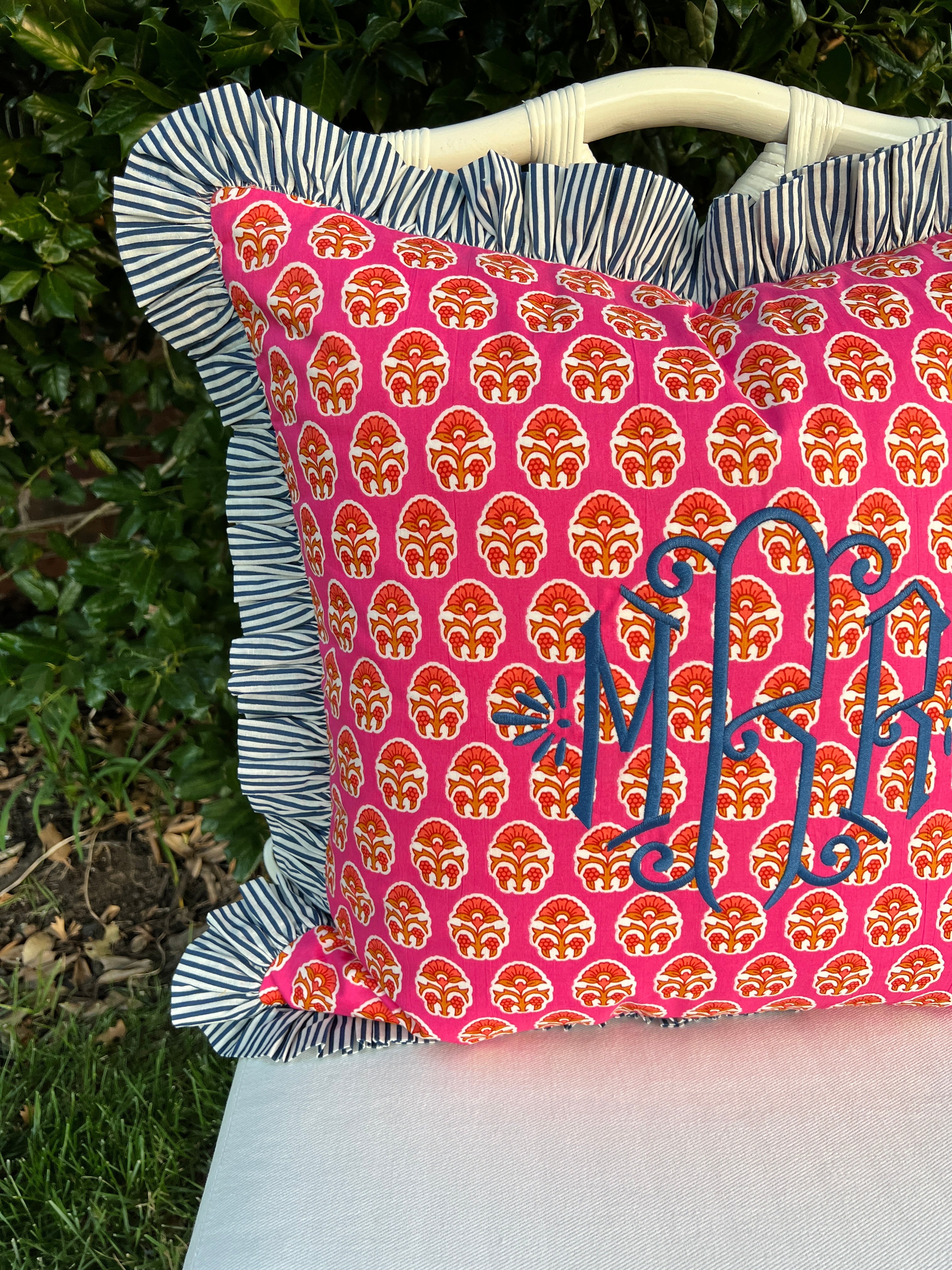 Pink and orange block print throw pillow cover with blue striped ruffle trim