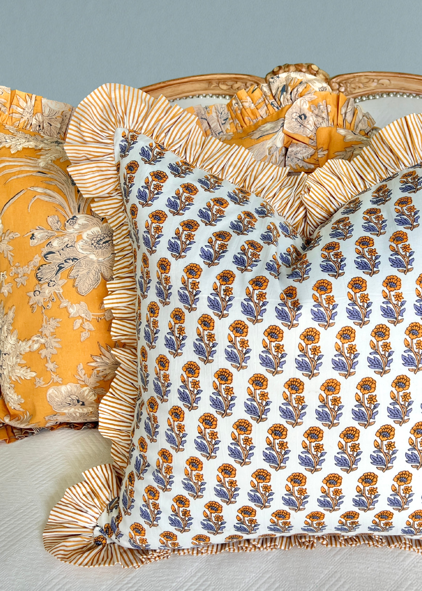 Yellow and blue block print pillow cover with striped contrast ruffle