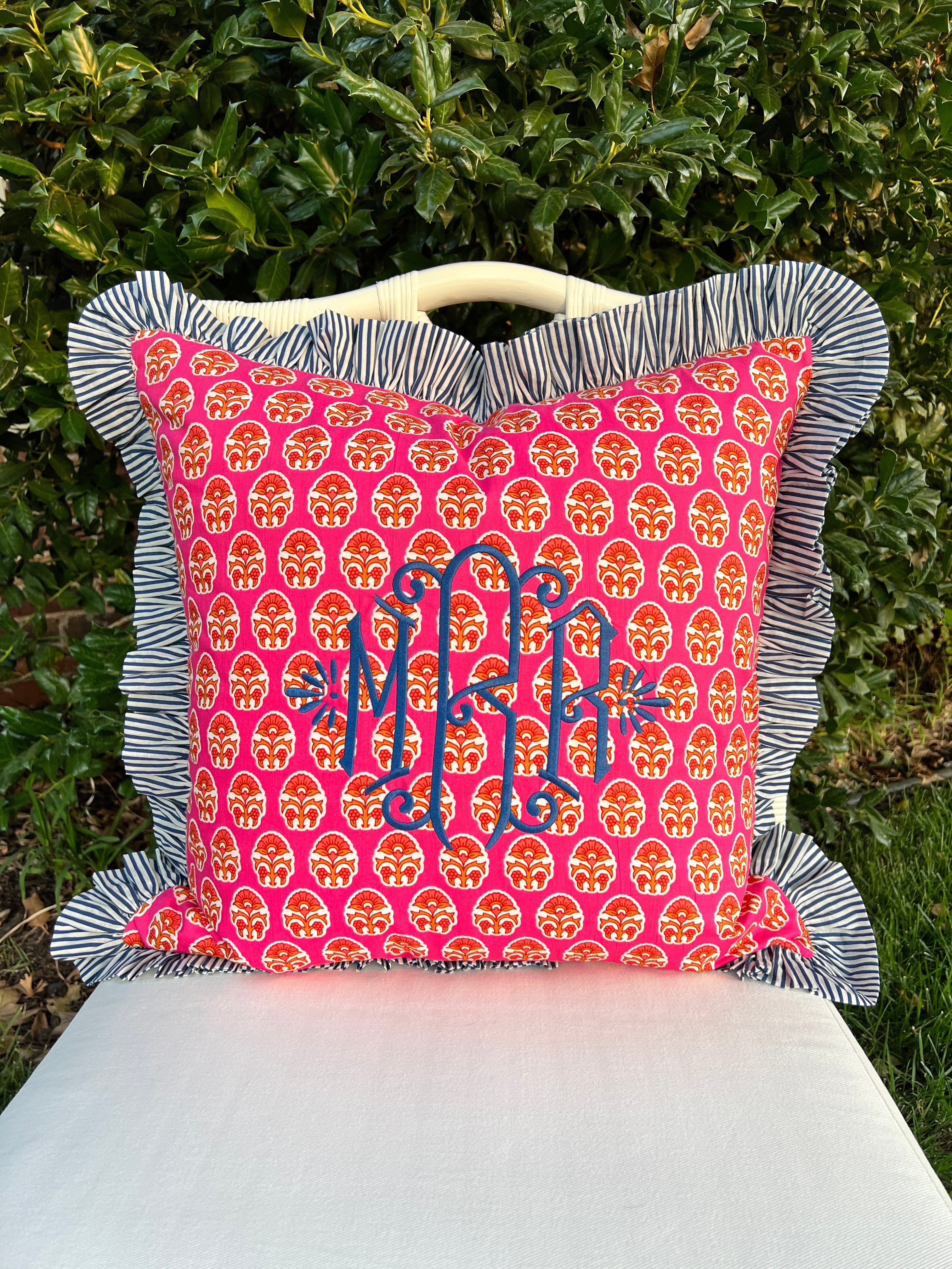 Pink and orange block print throw pillow cover with blue striped ruffle trim