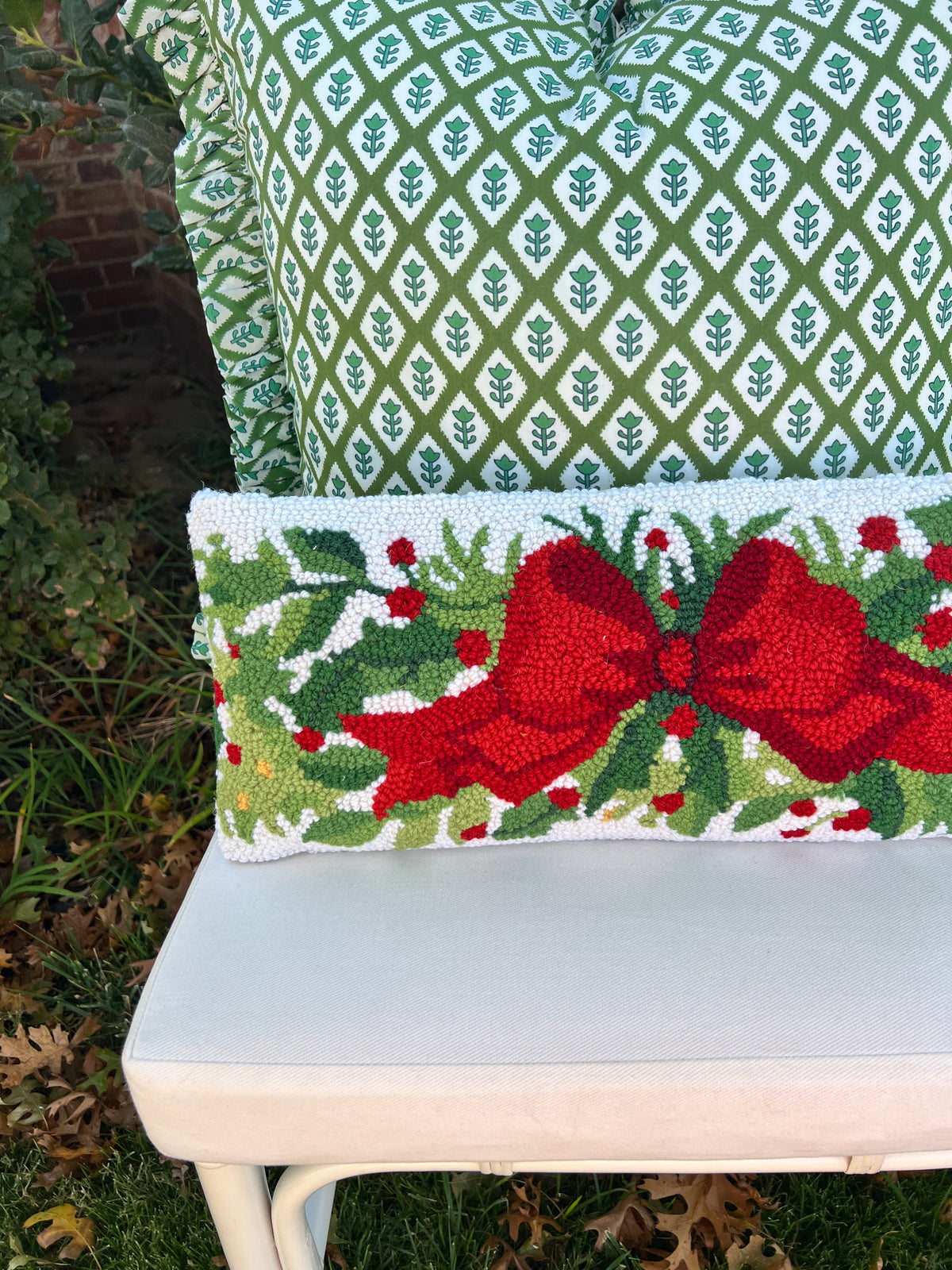 Red bow and greenery hand hooked lumbar pillow