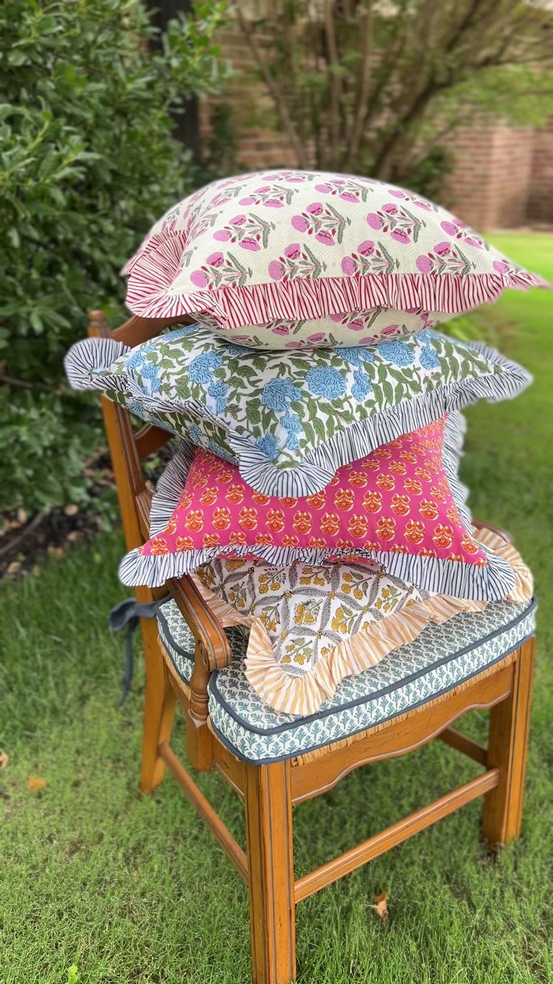Pink and orange block print throw pillow cover with blue striped ruffle trim