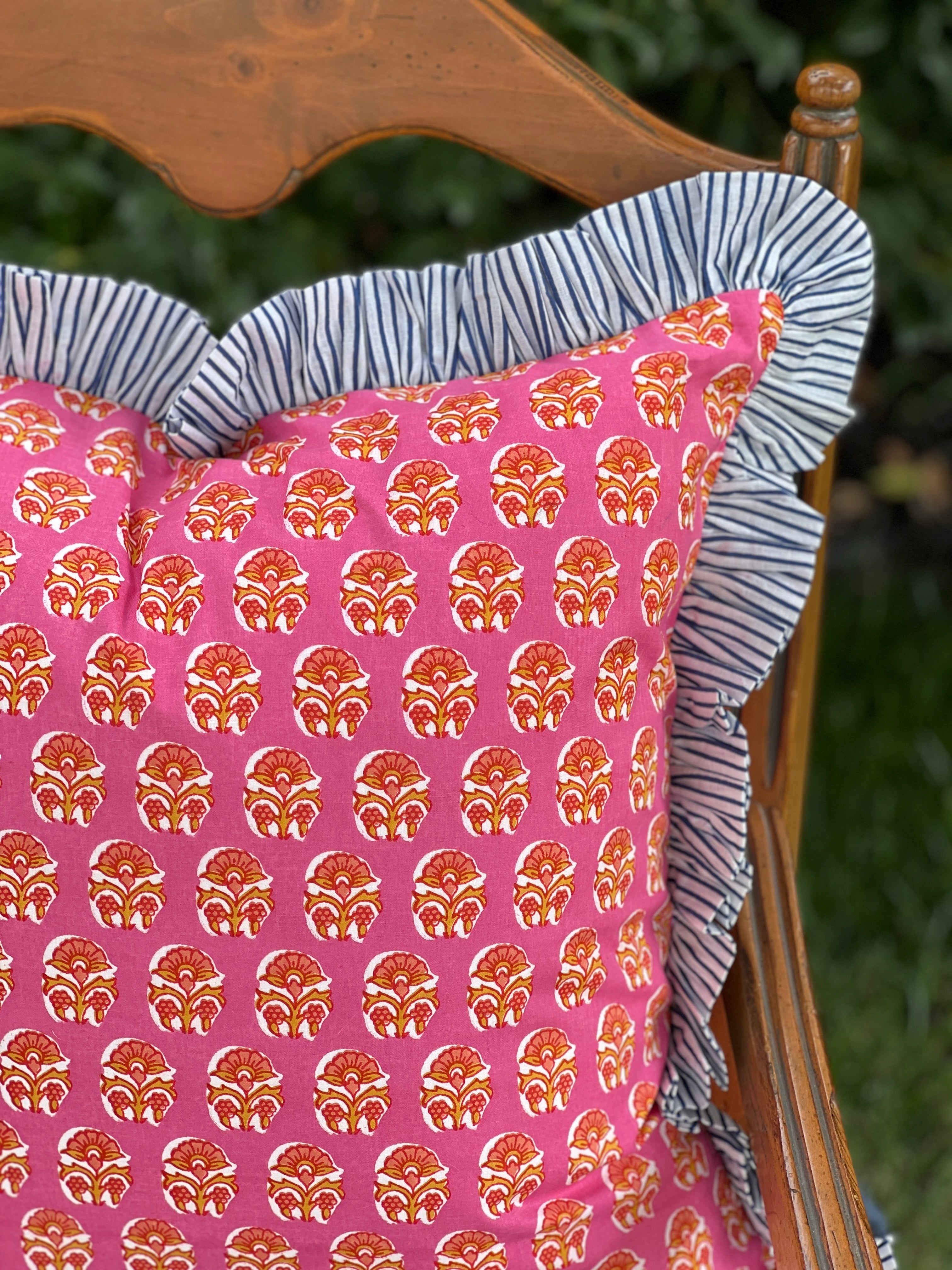 Pink and orange block print throw pillow cover with blue striped ruffle trim