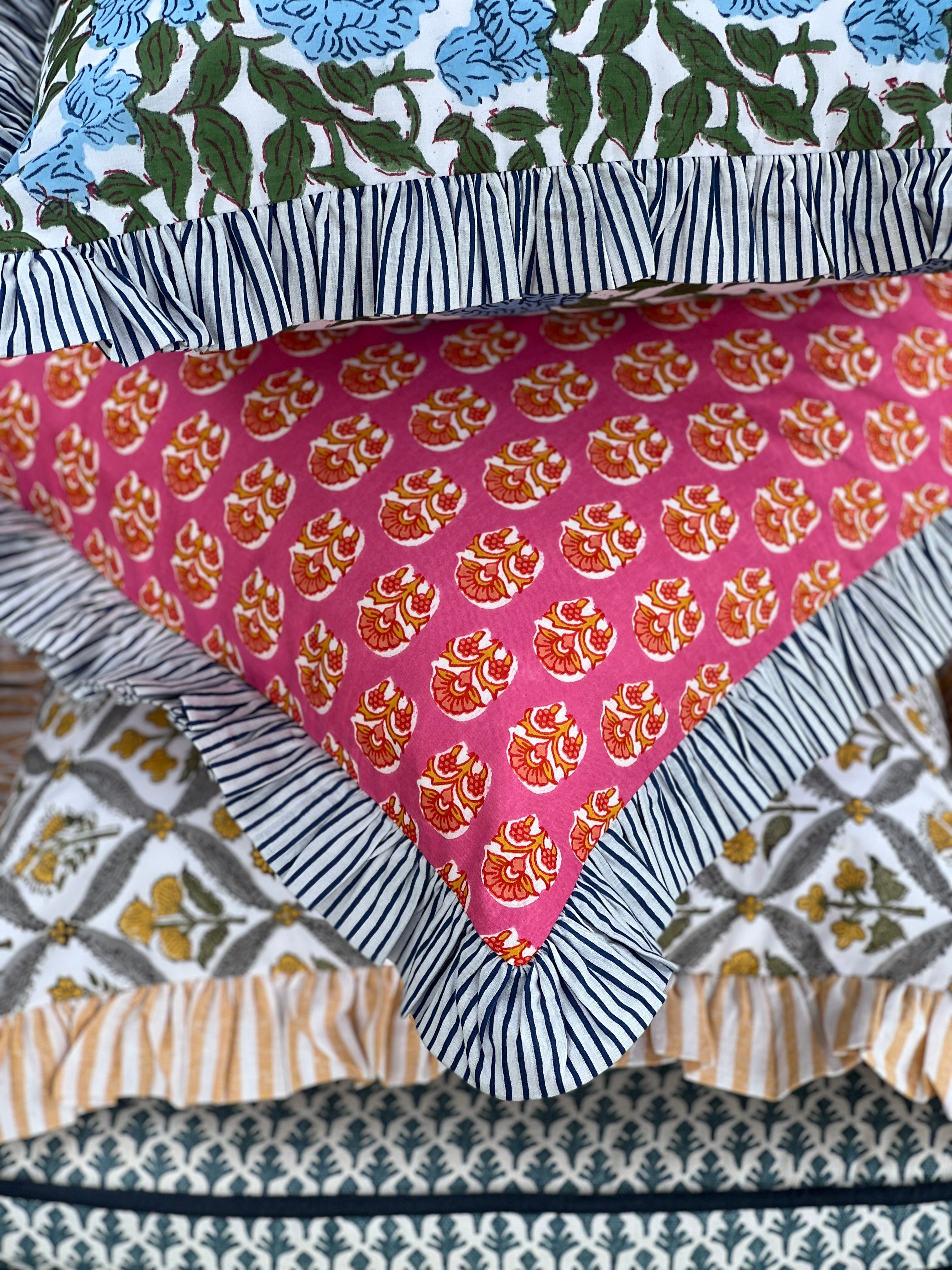 Pink and orange block print throw pillow cover with blue striped ruffle trim
