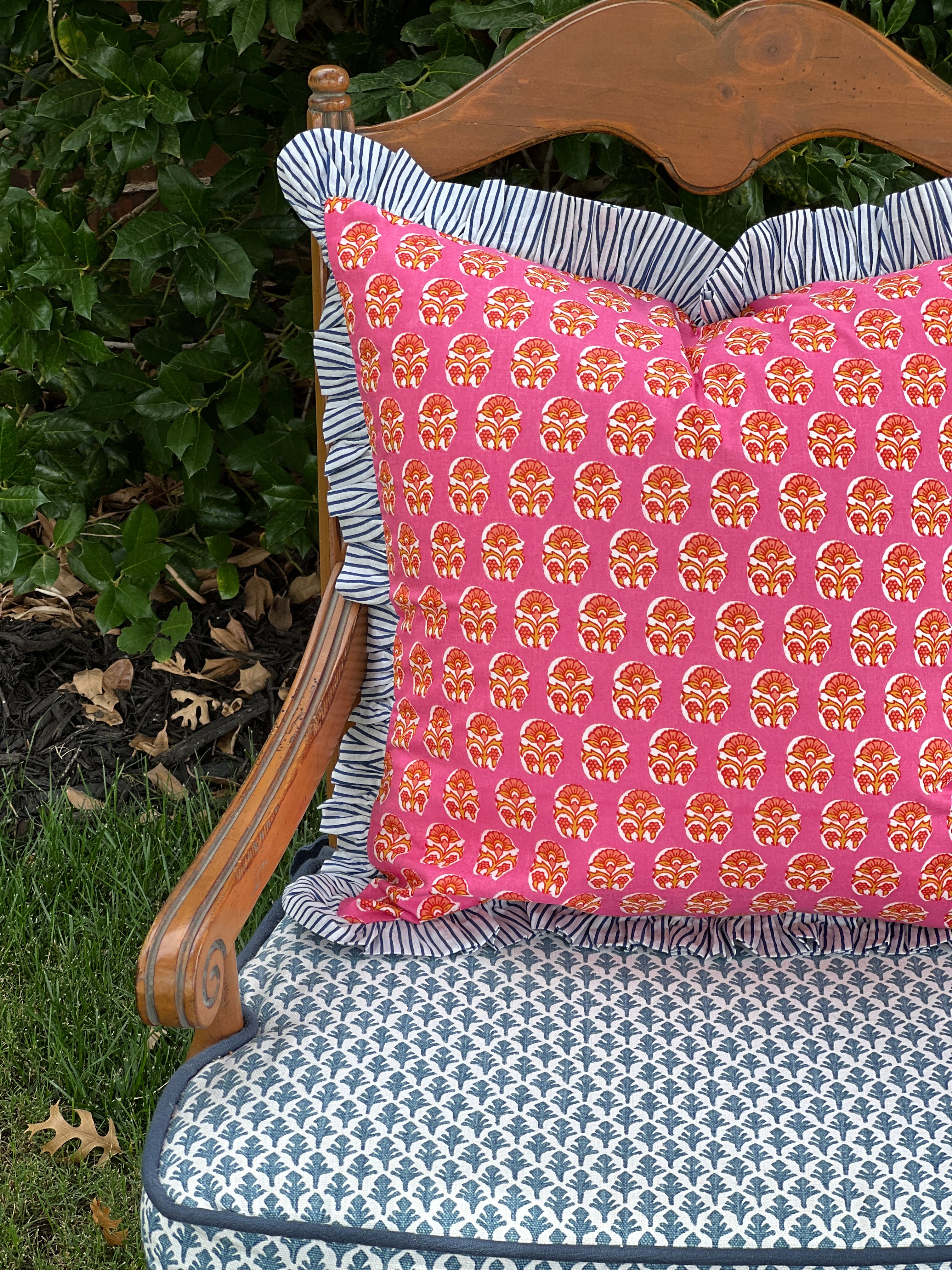 Pink and orange block print throw pillow cover with blue striped ruffle trim