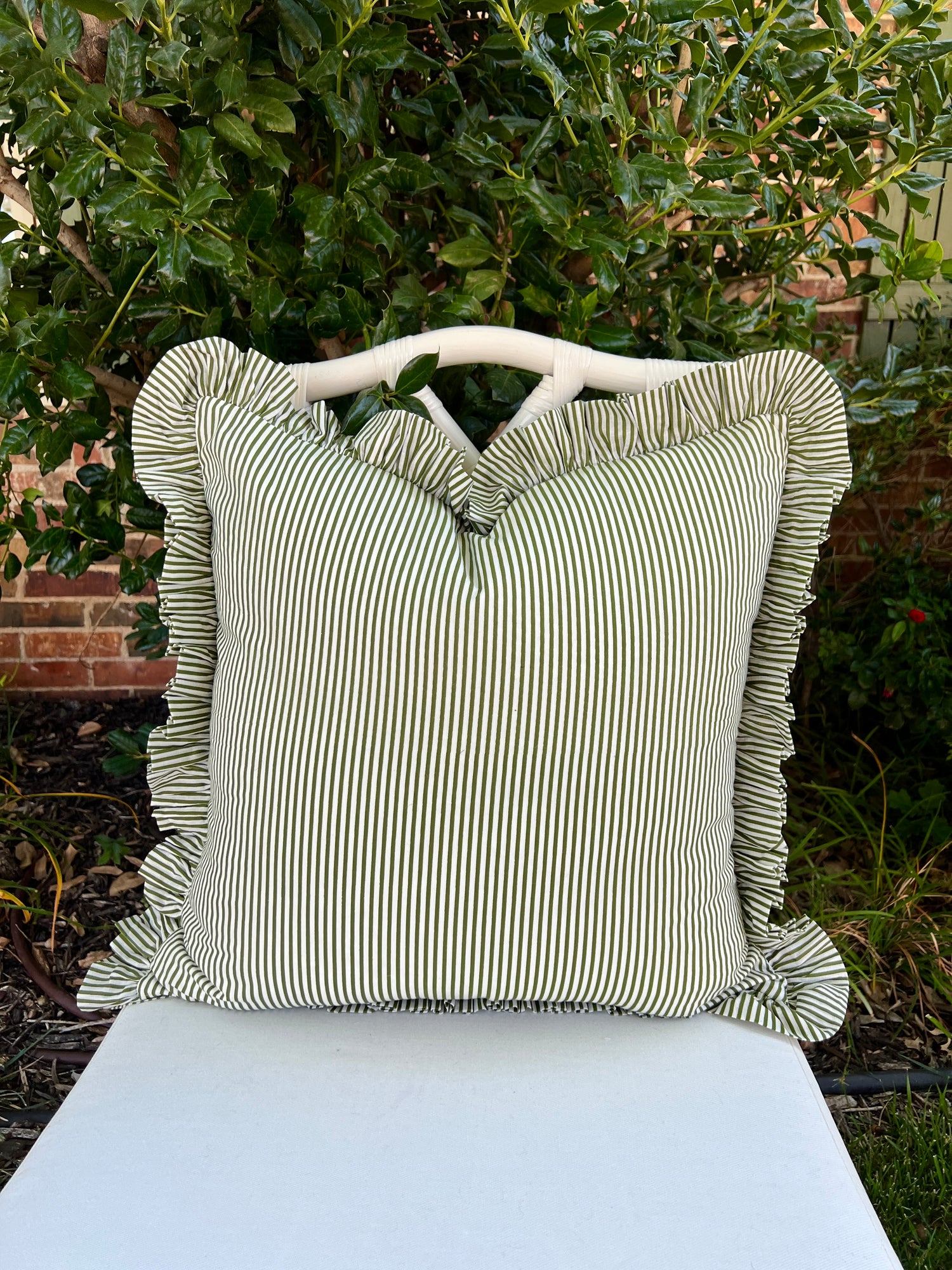 Green and white striped pillow cover with ruffle trim