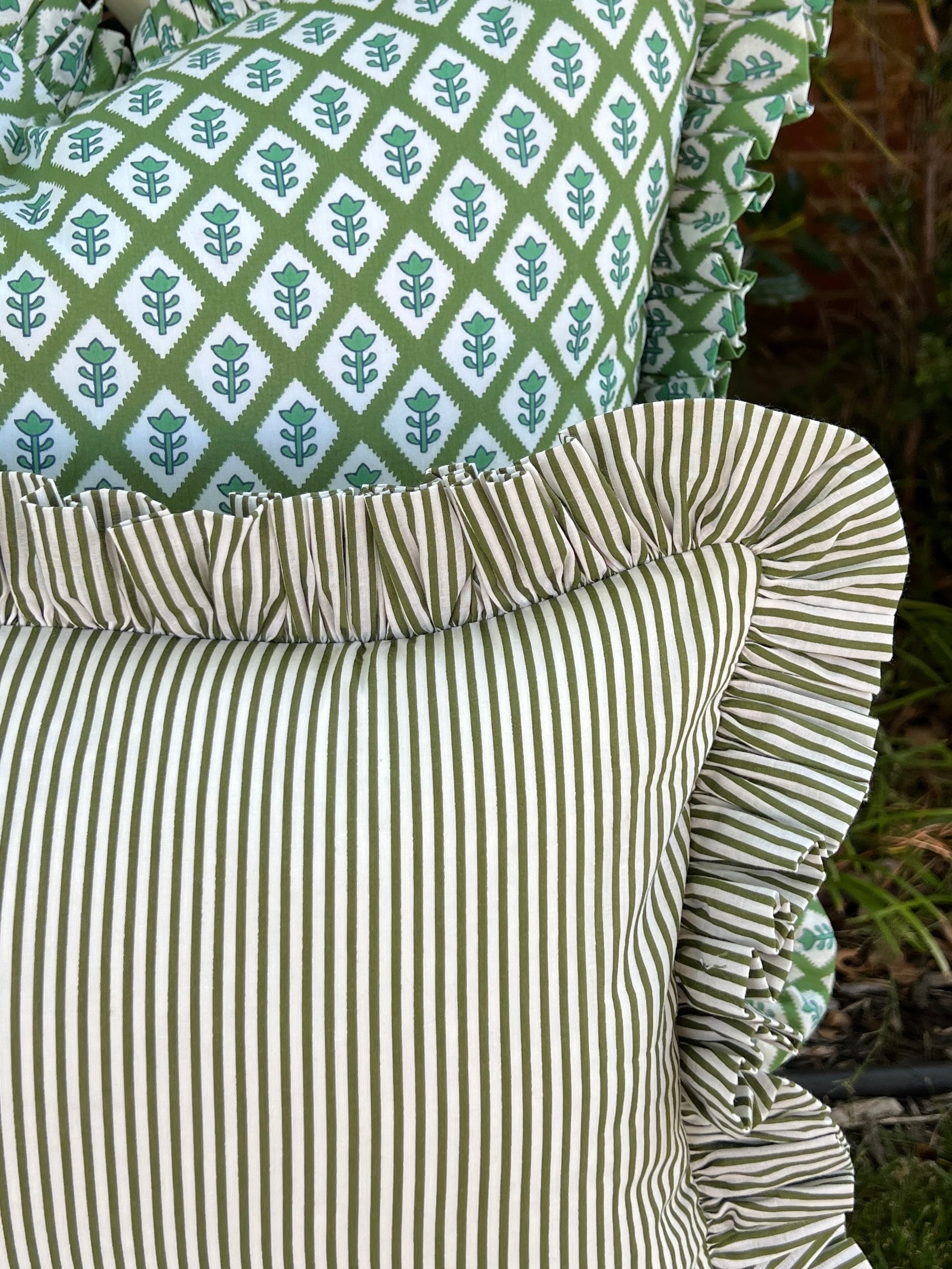 Green and white striped pillow cover with ruffle trim