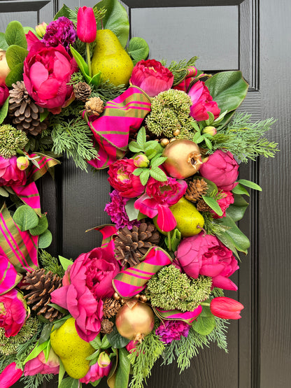 Lush fuchsia and green floral and fruit winter wreath