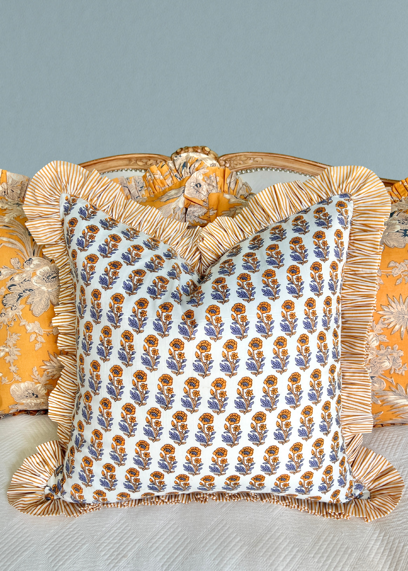 Yellow and blue block print pillow cover with striped contrast ruffle