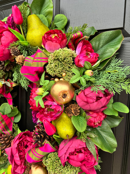 Lush fuchsia and green floral and fruit winter wreath