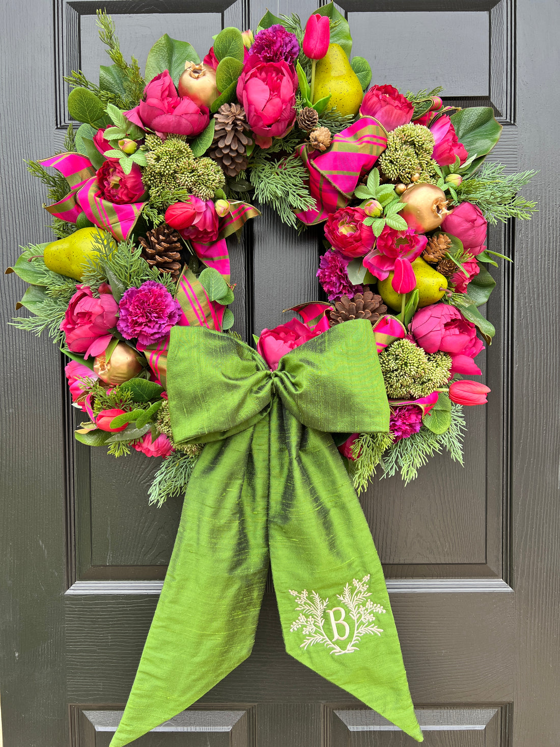 Lush fuchsia and green floral and fruit winter wreath