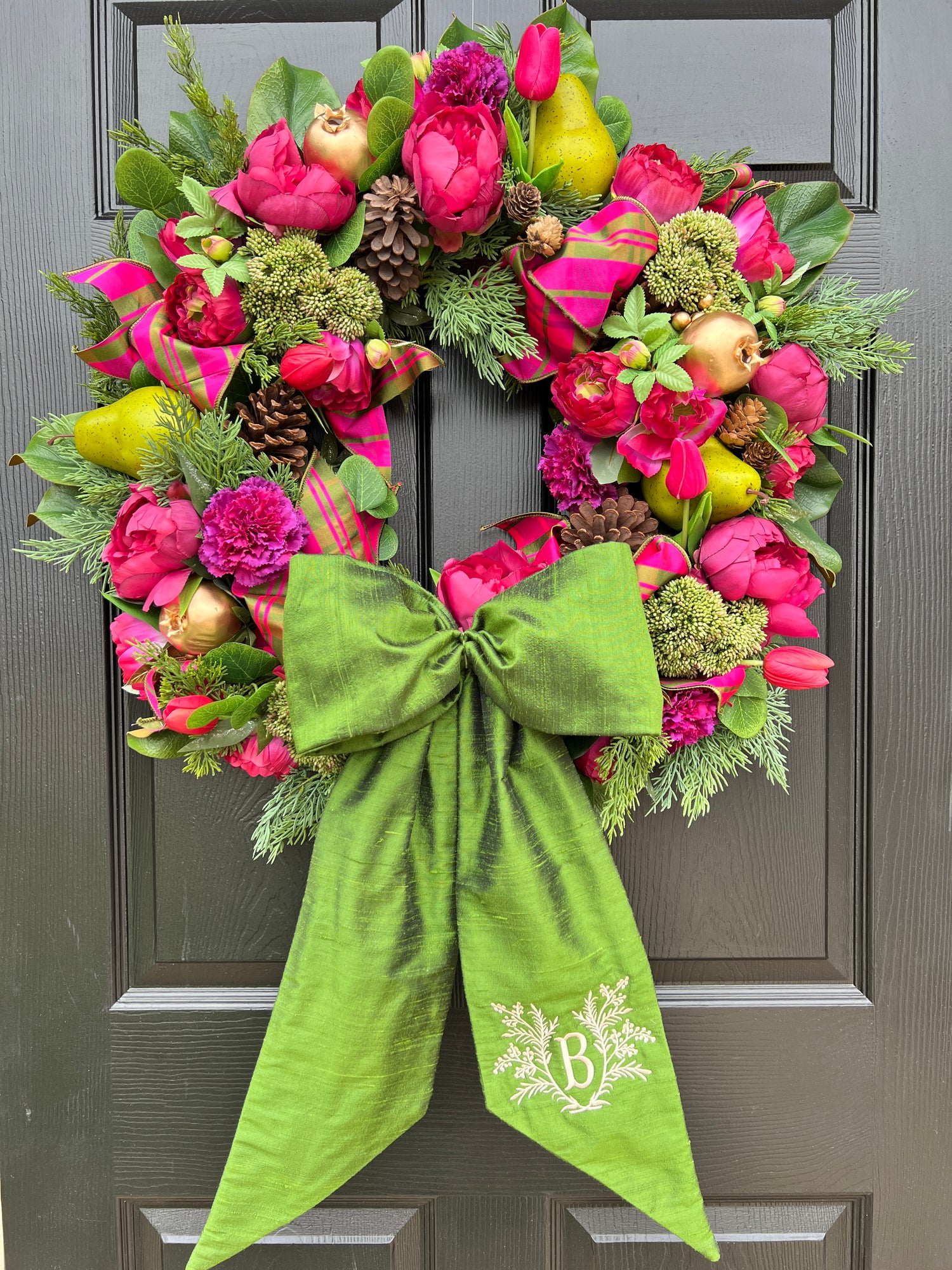 Lush fuchsia and green floral and fruit winter wreath