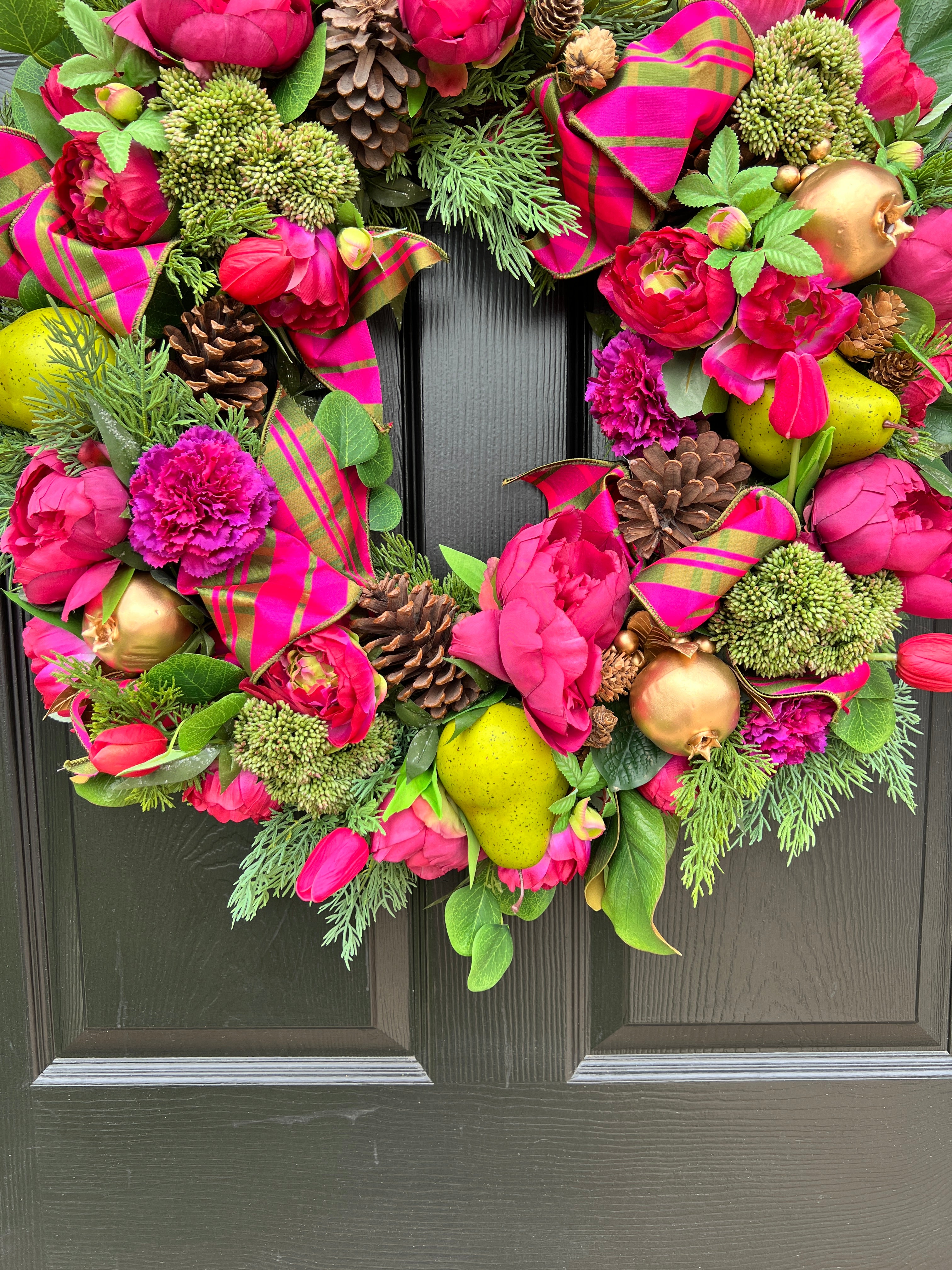 Lush fuchsia and green floral and fruit winter wreath