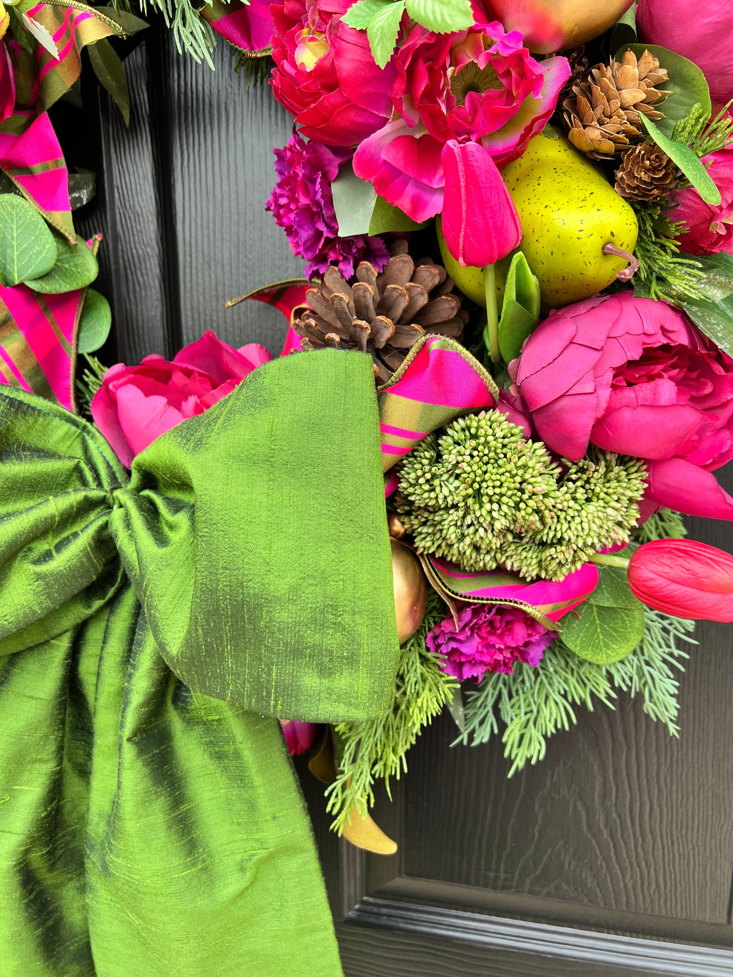 Lush fuchsia and green floral and fruit winter wreath