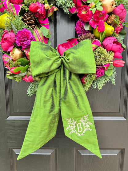 Lush fuchsia and green floral and fruit winter wreath