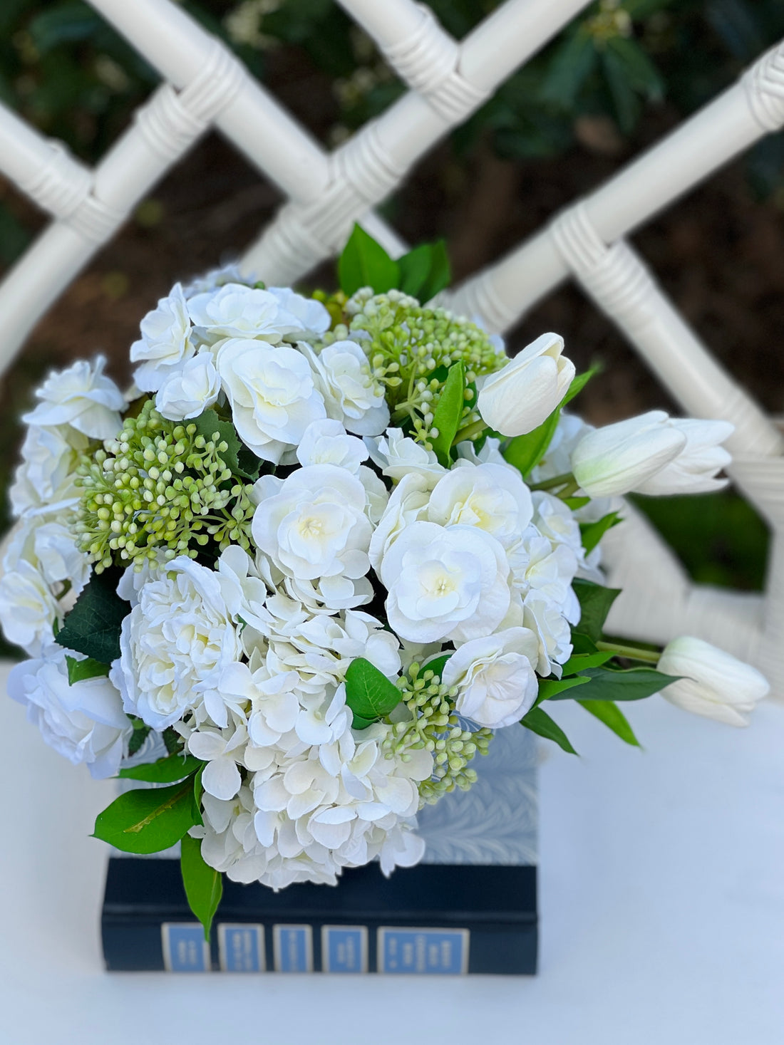 White faux floral arrangement in blue and white block print floral tole planter