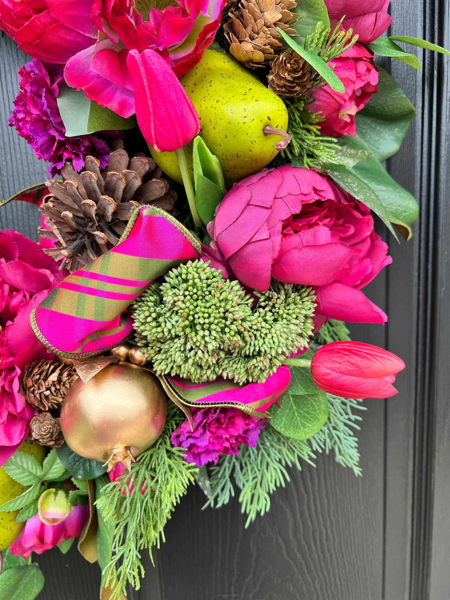 Lush fuchsia and green floral and fruit winter wreath