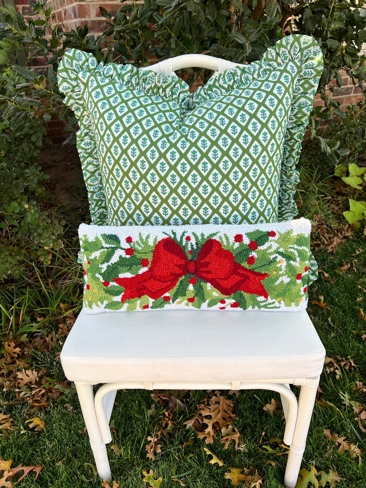 Red bow and greenery hand hooked lumbar pillow