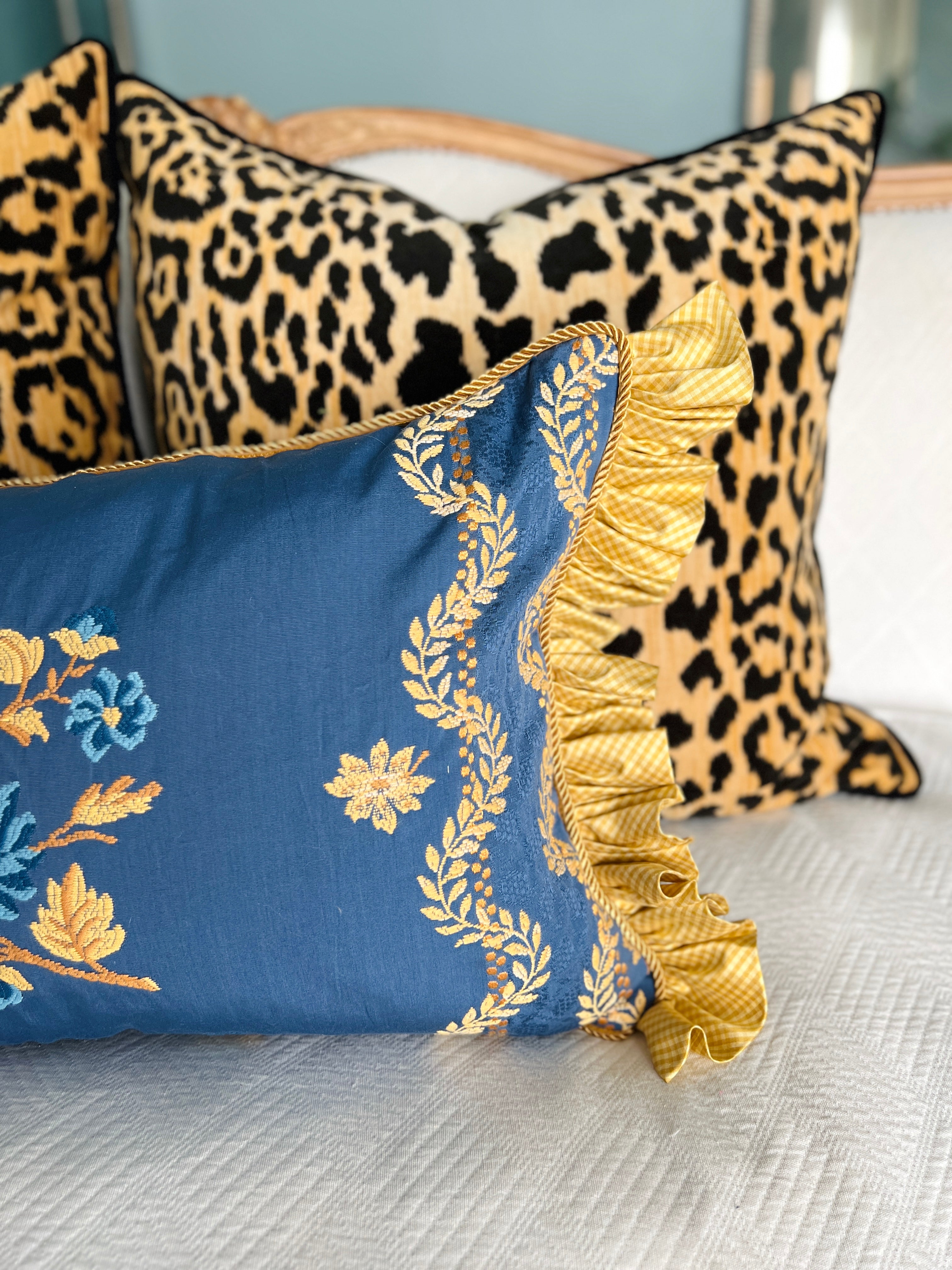 Blue and yellow embroidered pillow cover with silk ruffle trim